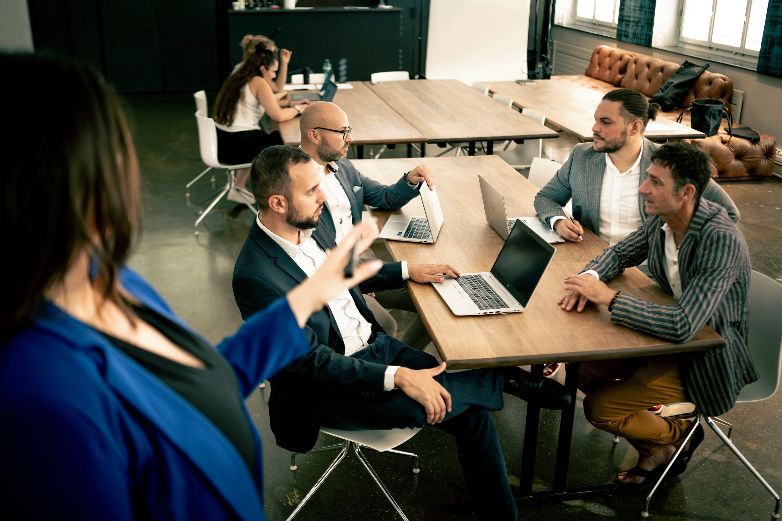 Personen die in einem Meetingraum sitzen und an einem Workshop teilnehmen.
