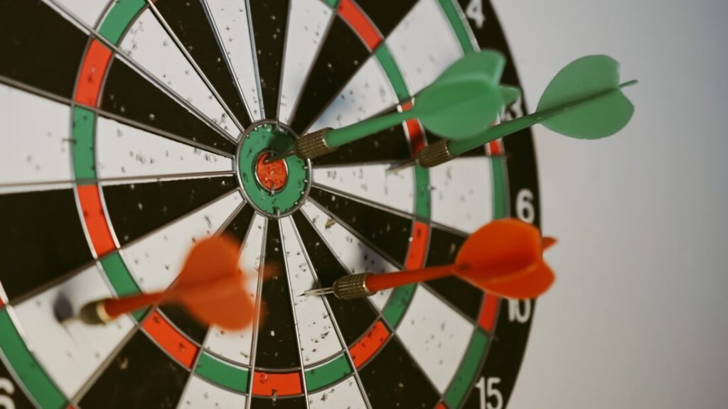 Pfeile die in einer Dartscheibe stecken.